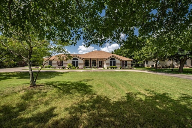 ranch-style house featuring stone siding and a front lawn