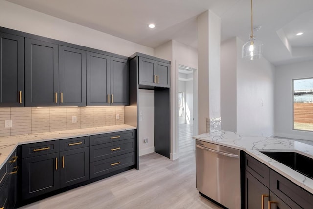 kitchen featuring pendant lighting, light wood-style flooring, stainless steel dishwasher, decorative backsplash, and light stone countertops