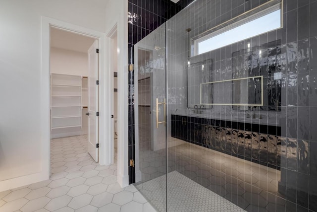 full bathroom with tile patterned flooring, a shower stall, and a spacious closet