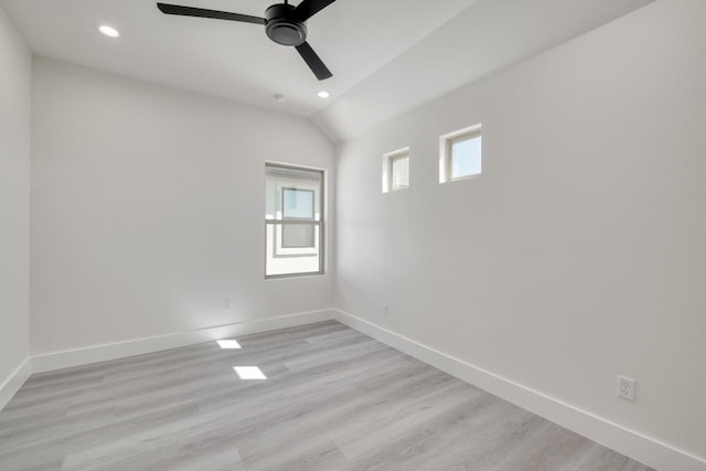 spare room featuring recessed lighting, baseboards, vaulted ceiling, and light wood finished floors