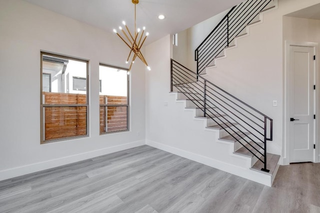 staircase featuring recessed lighting, wood finished floors, baseboards, and a chandelier