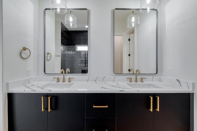 bathroom with double vanity, tiled shower, and a sink