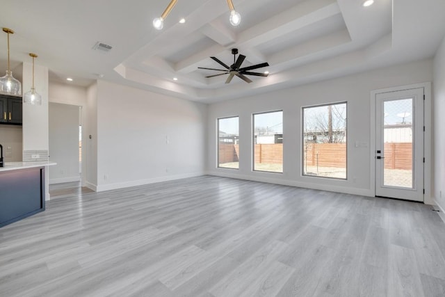 unfurnished living room with a raised ceiling, light wood-style flooring, a ceiling fan, recessed lighting, and baseboards