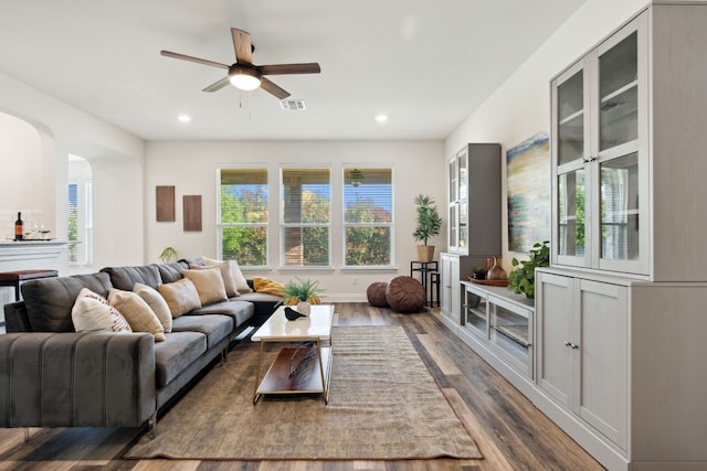 living area with visible vents, ceiling fan, dark wood finished floors, recessed lighting, and arched walkways