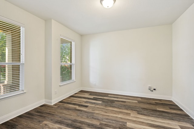 empty room featuring dark wood finished floors and baseboards