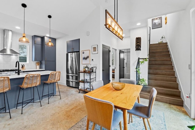 dining area with recessed lighting, stairway, baseboards, and a towering ceiling