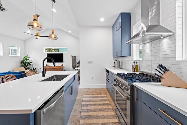 kitchen with blue cabinetry, appliances with stainless steel finishes, wall chimney exhaust hood, and a sink