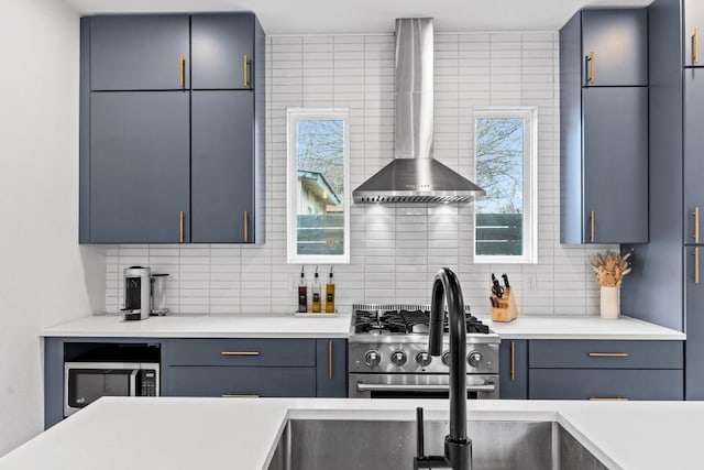 kitchen with stainless steel appliances, tasteful backsplash, light countertops, and wall chimney range hood