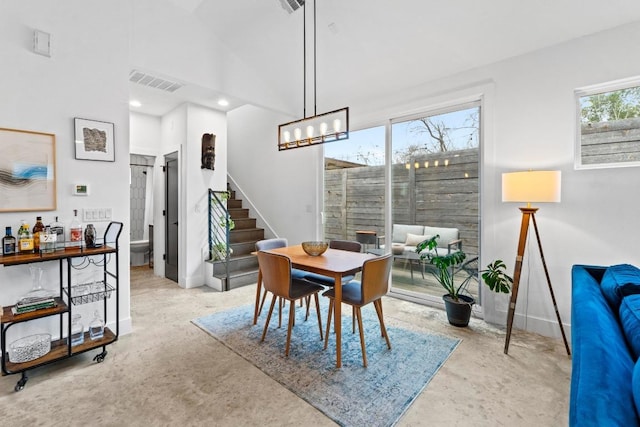 dining area with visible vents, stairway, concrete flooring, recessed lighting, and high vaulted ceiling