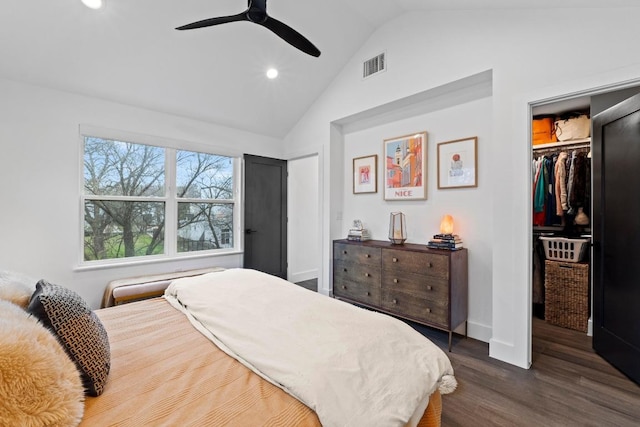 bedroom with a spacious closet, visible vents, vaulted ceiling, a closet, and dark wood-style flooring