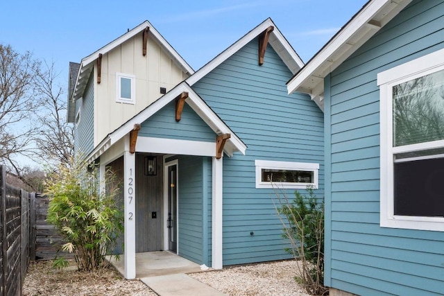 view of front of house with board and batten siding and fence