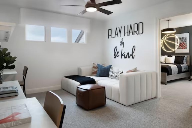 carpeted living area featuring baseboards and a ceiling fan