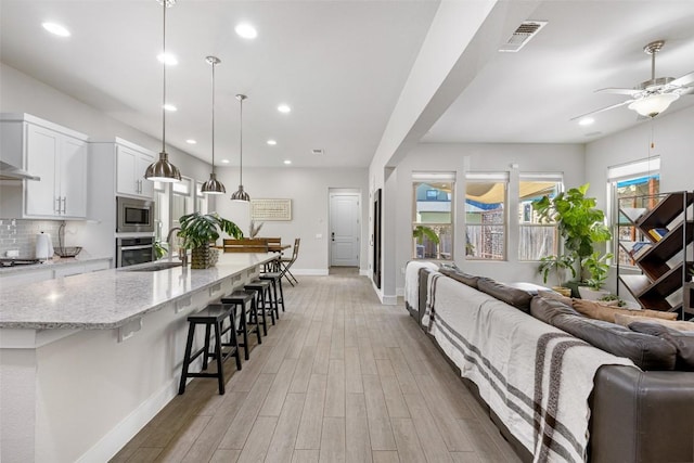 2505 Moreno St, Austin, TX 78723 - living area with baseboards, a ceiling fan, light wood-style flooring, and recessed lighting