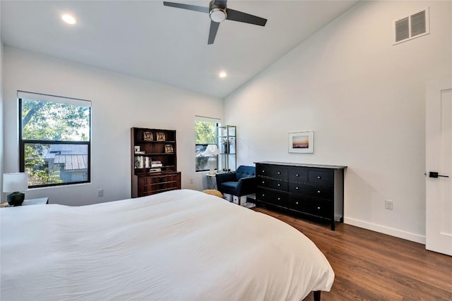 bedroom with lofted ceiling, multiple windows, dark wood-style floors, and visible vents