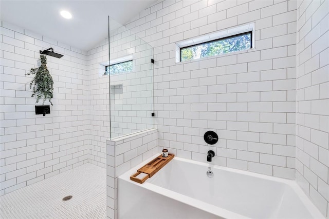 bathroom featuring tiled shower and a tub to relax in