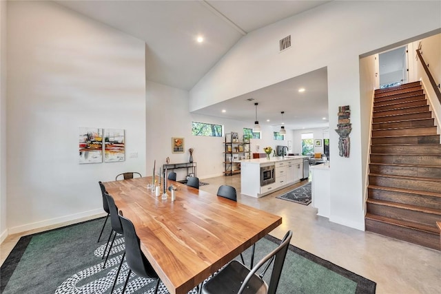 dining area featuring recessed lighting, visible vents, concrete flooring, and stairs