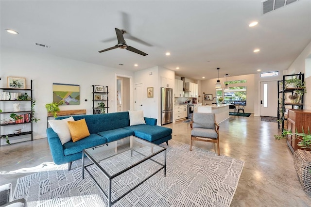 living room with recessed lighting, visible vents, finished concrete flooring, and ceiling fan