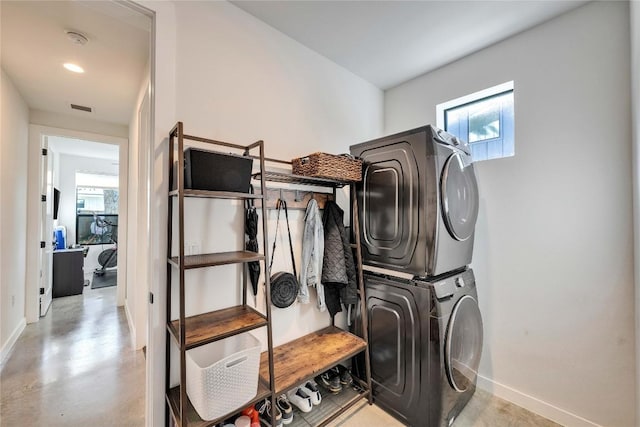 clothes washing area featuring visible vents, recessed lighting, stacked washer / drying machine, baseboards, and laundry area