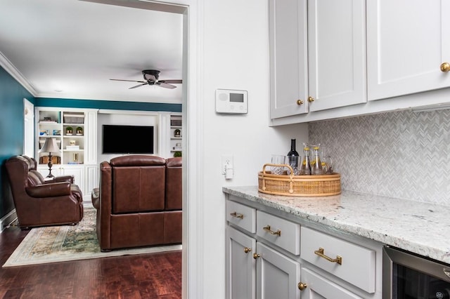 kitchen featuring a ceiling fan, backsplash, open floor plan, dark wood finished floors, and light stone countertops