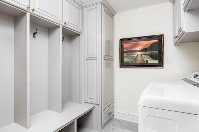 laundry area featuring baseboards, cabinet space, marble finish floor, and washer and clothes dryer