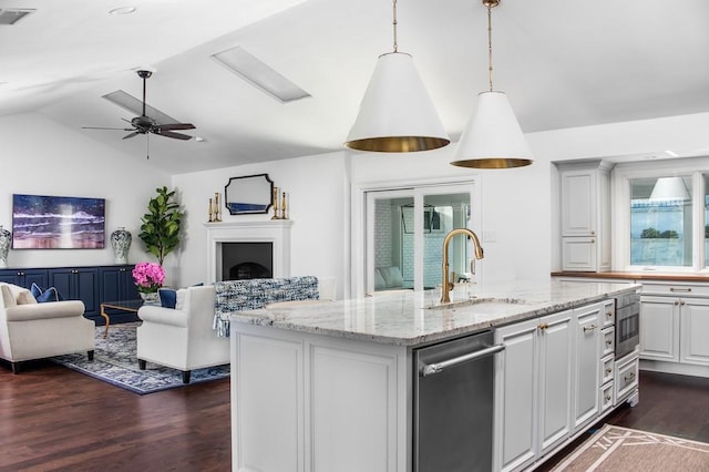 kitchen featuring visible vents, lofted ceiling, a sink, dishwasher, and open floor plan