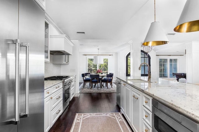 kitchen with premium range hood, visible vents, dark wood-type flooring, a sink, and stainless steel appliances