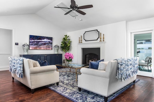 living area with a ceiling fan, dark wood-style floors, a fireplace, and vaulted ceiling