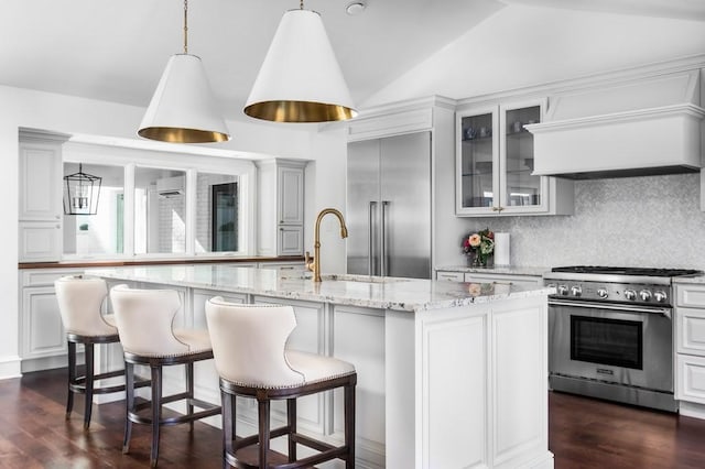 kitchen with glass insert cabinets, dark wood-type flooring, lofted ceiling, decorative backsplash, and high end appliances