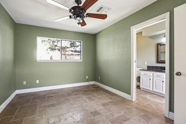 unfurnished room featuring visible vents, baseboards, stone tile flooring, and a ceiling fan