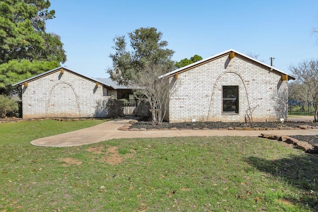 view of front of property featuring brick siding and a front yard