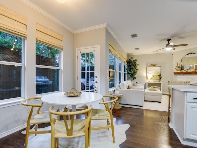 dining room featuring crown molding, dark wood-style floors, visible vents, and baseboards