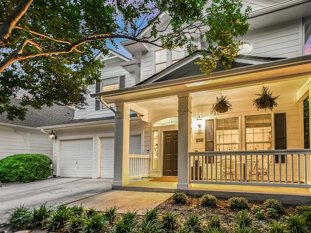 view of front of house featuring covered porch, driveway, and an attached garage