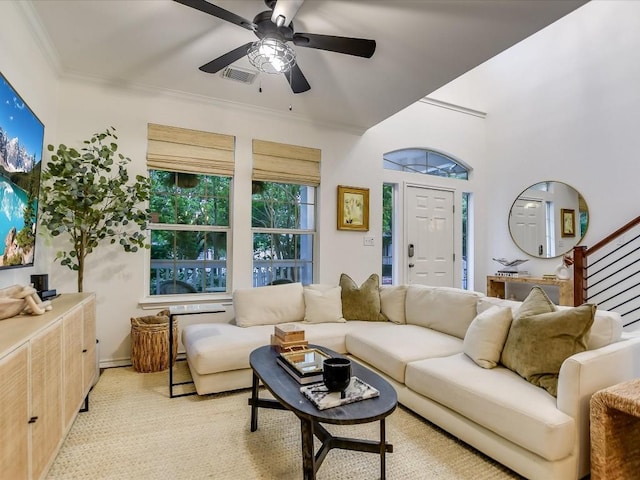 living area featuring stairway, visible vents, ceiling fan, and crown molding