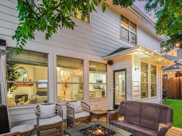 view of patio / terrace featuring an outdoor living space with a fire pit and fence