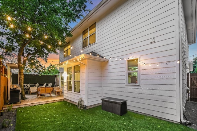 rear view of house with a yard, a deck, and fence