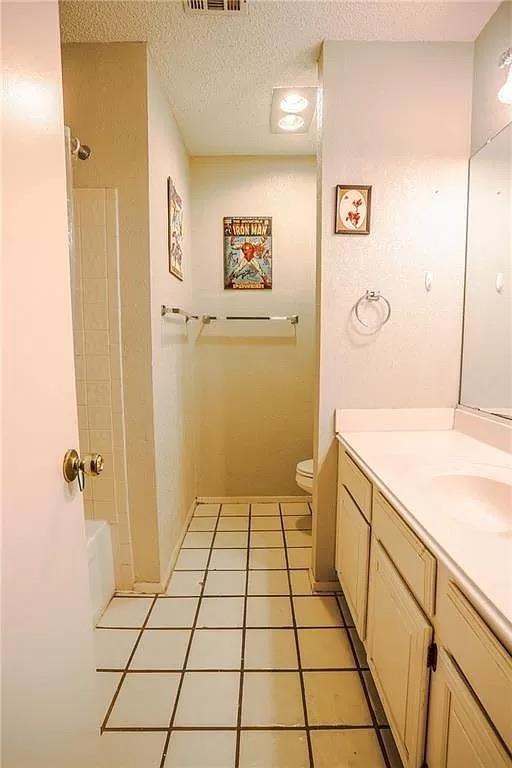 bathroom featuring vanity, toilet, and a textured ceiling