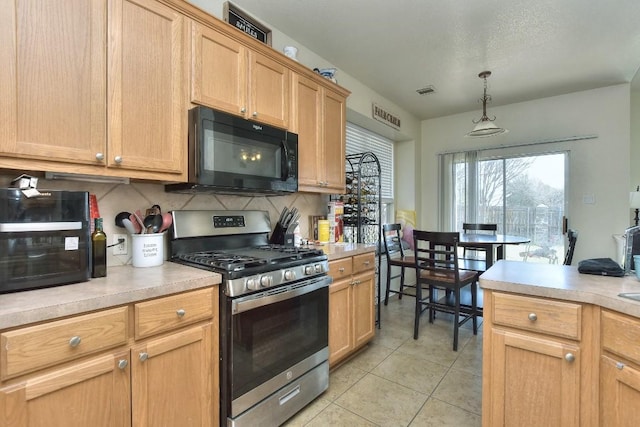 kitchen featuring light tile patterned floors, stainless steel range with gas stovetop, decorative backsplash, light countertops, and black microwave