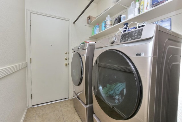 laundry room featuring light tile patterned floors, laundry area, and washing machine and dryer