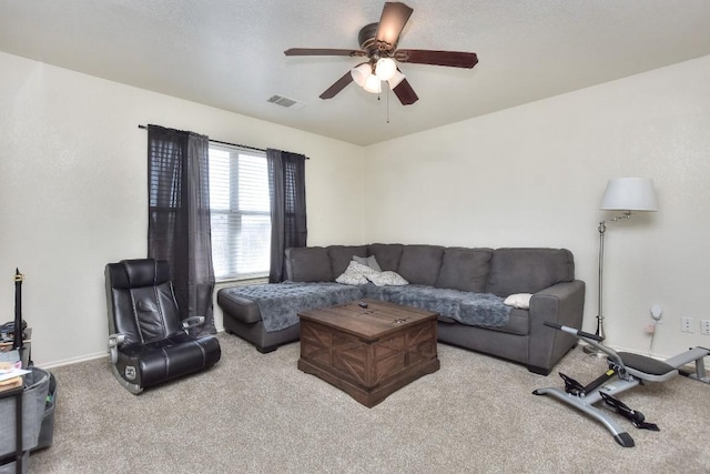 living area with baseboards, visible vents, carpet floors, and ceiling fan