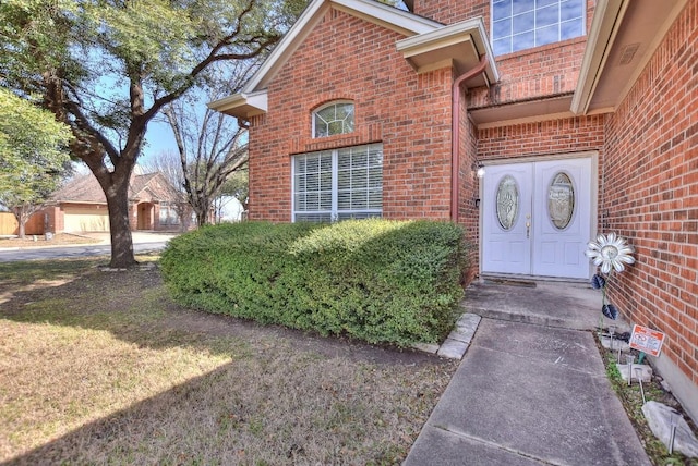 entrance to property featuring brick siding