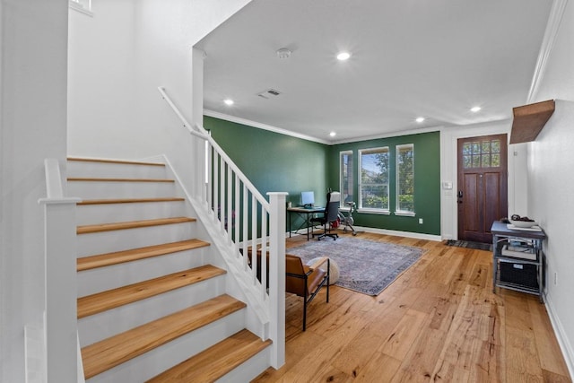 foyer entrance with baseboards, visible vents, ornamental molding, stairs, and hardwood / wood-style flooring