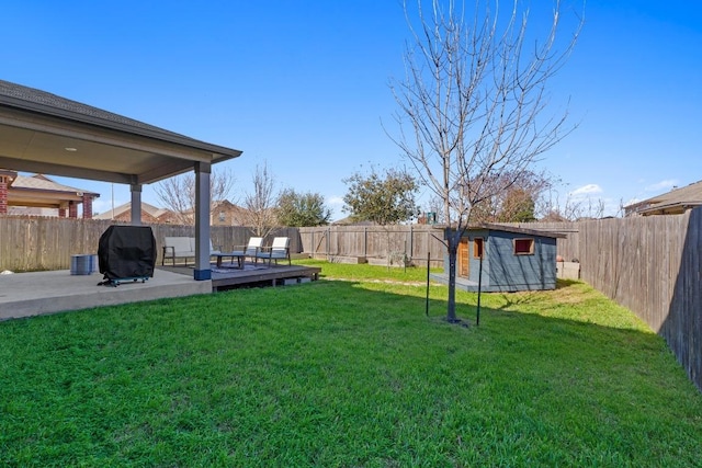 view of yard with an outdoor structure, a storage shed, and a fenced backyard