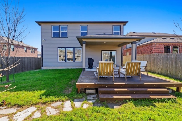 back of house with a yard, a fenced backyard, and a deck