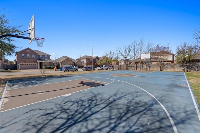 view of sport court featuring a residential view, community basketball court, and fence