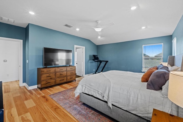 bedroom with visible vents, baseboards, lofted ceiling, and light wood-style floors