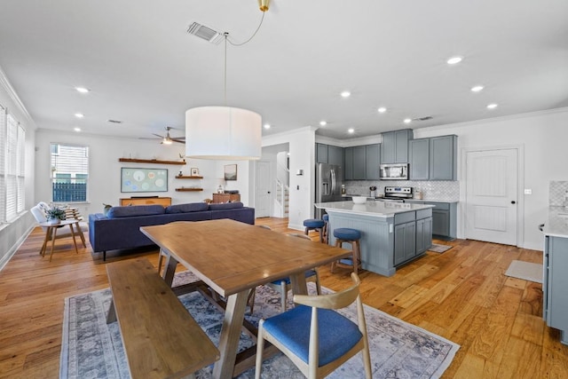 dining space with light wood-type flooring, visible vents, ornamental molding, and recessed lighting