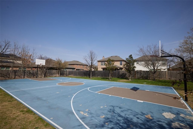 view of sport court with a lawn, basketball court, and fence