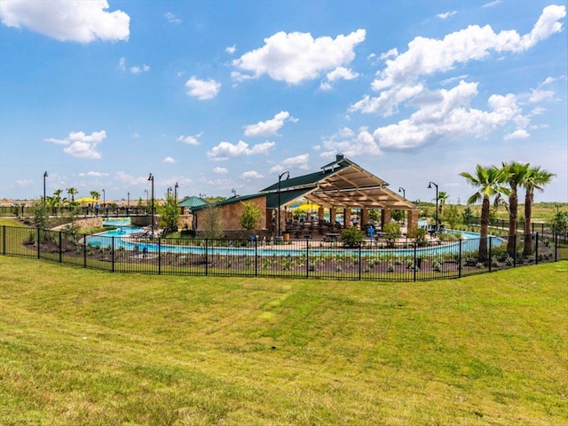 view of jungle gym featuring a community pool, a lawn, and fence