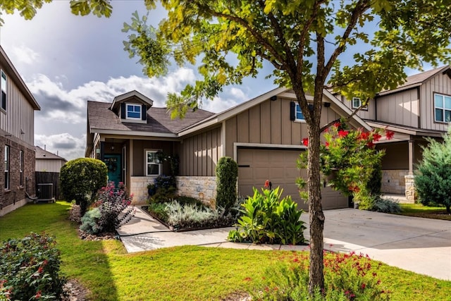 view of front of home featuring stone siding, cooling unit, board and batten siding, concrete driveway, and a front yard