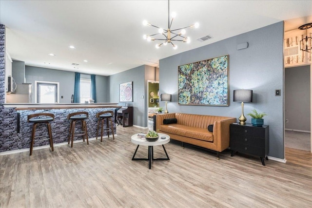 living room featuring visible vents, baseboards, and wood finished floors